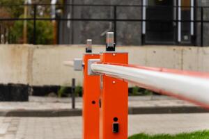 The photograph showcases an orange barrier prominently placed in an urban environment, focusing on its sleek design and structural elements. The area is well-maintained and shows signs of development photo