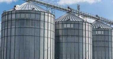 Multiple large silos are visible at an agro-processing plant, showcasing storage facilities for harvested grains. The structure is well-maintained and functional photo