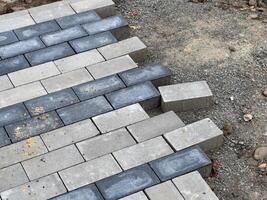 Workers carefully lay the paving stones in a pattern to construct a robust pavement at a construction site, ensuring precise alignment for durability photo