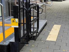 This entrance features a well-designed wheelchair ramp and clear signage, ensuring accessibility for all individuals entering the building effortlessly photo