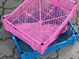 Brightly colored crates are stacked together in a lively market filled with activity, ready to display various goods for eager customers photo