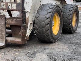 A bobcat, a small compact loader, is parked at a construction site photo