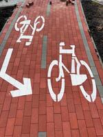 The sidewalk features a bike lane sign with a cyclist graphic and directional arrow, emphasizing the designated path for cyclists in an urban setting photo