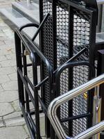 A metallic ramp is installed next to a set of stairs, ensuring accessibility for individuals with mobility challenges in a public area photo