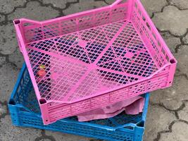 Stacked crates in bright colors rest on a patterned pavement, reflecting a lively market atmosphere filled with activity and goods ready for sale photo