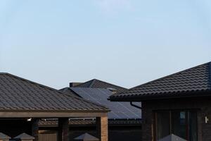 Solar panels are installed on the rooftops of modern homes, showcasing a sustainable energy choice in a quiet suburban area during a sunny day photo