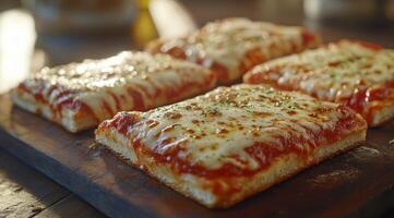 Four cheesy, square pizzas on wooden board photo