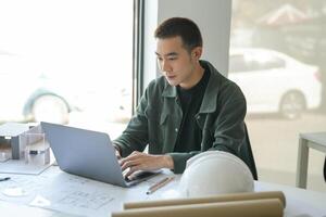 Architecture man sitting at a desk with a laptop. photo