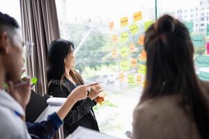 a group of people standing around a window with sticky notes on it. photo