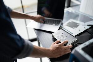 Engineer working on a laptop computer with a motherboard photo