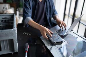 engineer working on a laptop computer with a hard drive photo
