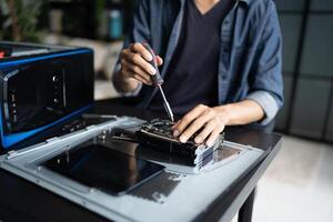 Engineer is working on a computer with a screwdriver in room photo