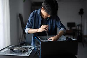 IT Engineer man is fixing a computer in a room photo