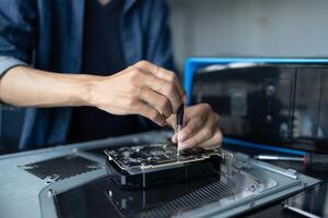 IT Engineer man is repairing a computer with a screwdriver photo