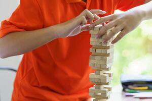 a person playing with wooden blocks on a table photo