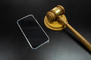 mobile phone and judge's gavel on black background photo