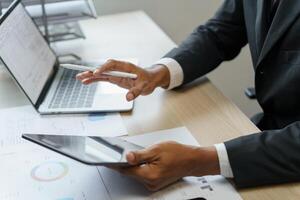 a man in a suit is using a tablet and pen photo