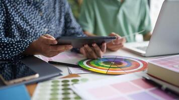 two creative is using a tablet and a color wheel photo
