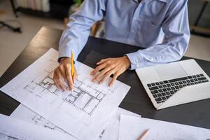 Architecture Man man is working on blueprints with a pencil photo