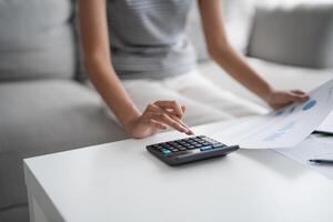 a woman is using a calculator to calculate the cost of a home photo