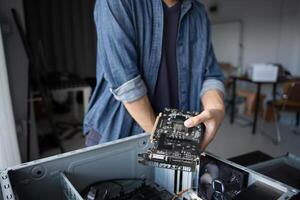IT Engineer holding a computer motherboard in his hands photo