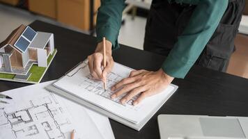 architectural design concept, architect drawing on paper with model house photo