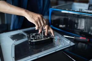 IT Engineer is repairing a computer with a screwdriver photo