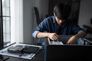 a IT engineer man is working on a computer with a laptop photo