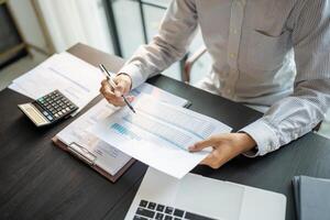 Close up of businessman hands signing or writing document paperwork and report Auditor analysis male professional hand making notes with Document photo