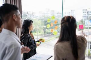 business people standing around a window with sticky notes on them photo