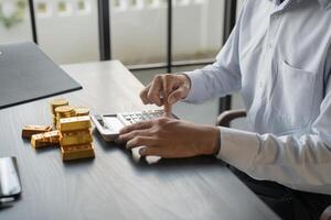 a man is using a calculator to calculate the value of gold photo