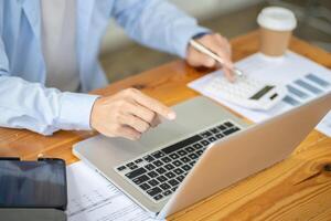 a man is using a laptop computer with a calculator. photo
