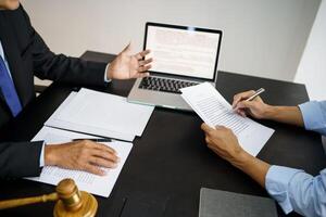 lawer sitting at a table with a laptop and papers with clien photo