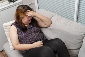 Sad Overweight plus size woman thinking about problems on sofa upset girl feeling lonely and sad from bad relationship or Depressed photo