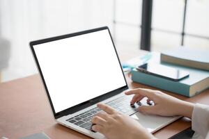 a person typing on a laptop computer with a blank screen photo