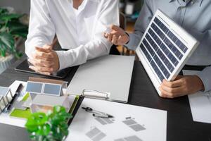 two engineers sitting at a table with a solar panel. photo