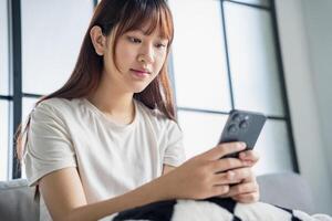 Asian woman using smartphone texting message browsing photo