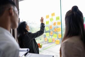 a group of people standing around a window with sticky notes on it photo