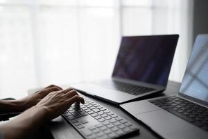 Asian man software engineer Working on Computer at office desk for writing program code. IT Software Engineer finding errors tech support devops creating digital. photo