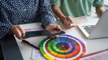 a two person is using a tablet and a color wheel photo