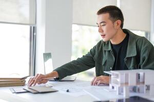 Architecture Man is working on a project at a desk photo