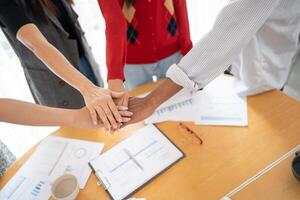Team building of people Asian business hands stack unity and support Team fold their hands on each other photo