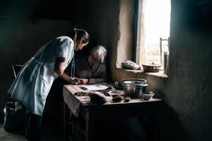 A woman in a white coat is helping an elderly woman photo