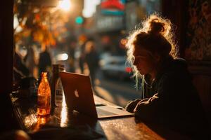 A woman sitting at a table with a laptop photo