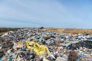 Waste Accumulation Site Shows Piles of Trash Under Blue Sky, Demonstrating Environmental Concerns with Landfill Management photo