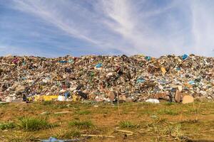 Massive Landfill Accumulation Overflows in an Environmental Disaster Scene Under a partly Cloudy Sky photo