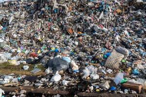 Overflowing landfill showing vast accumulation of garbage and waste materials creating large pile with varied composition photo