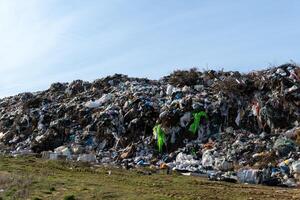 Massive landfill filled with mixed trash and waste material creates environmental challenge and pollution concern on sloping ground photo