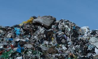 Large Pile of Mixed Waste and Refuse Against a Clear Sky photo