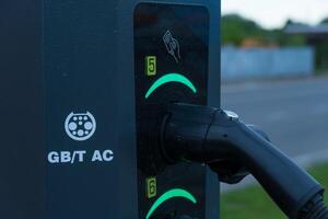 Electrical Automobile Charging Station with Plug Connected at Nighttime photo